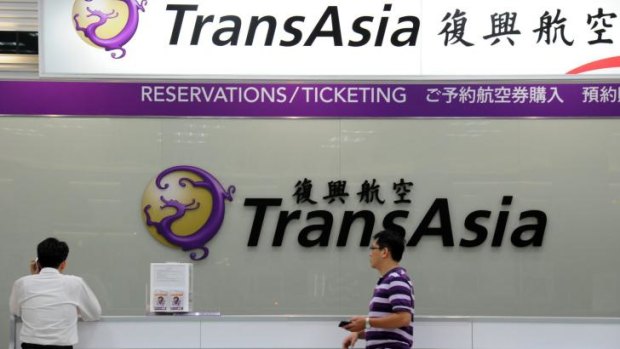 Local journalists wait in front of a TransAsia reservations desk at the Sungshan airport in Taipei after at least 47 people were killed in a plane crash in Taiwan.