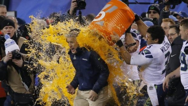 Seattle Seahawks quarterback Russell Wilson dumps Gatorade on head coach Pete Carroll late in the game against the Denver Broncos during Super Bowl XLVIII.