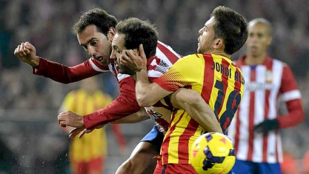 Squeezed: Diego Godin of Atletico Madrid (L) vies for possession with Barcelon defender Jordi Alba.