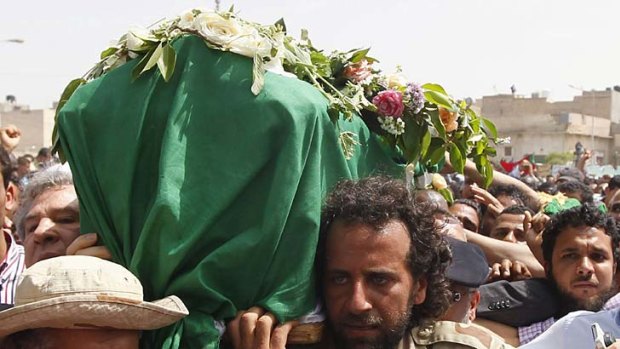 Coffin bearers in Tripoli at the reported burial of Colonel Gaddafi’s youngest son and three of his grandchildren.