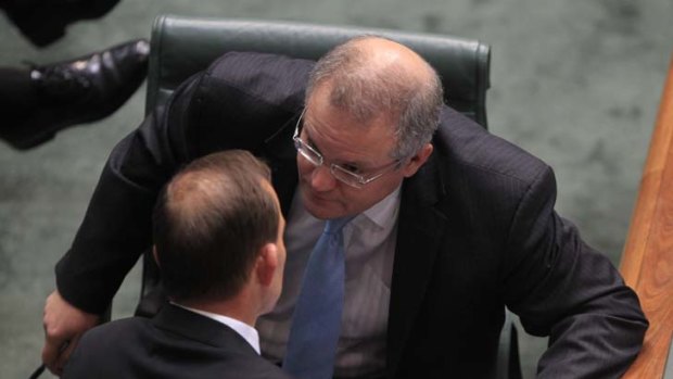 Opposition Leader Tony Abbott confers with shadow immigration spokesperson Scott Morrison.