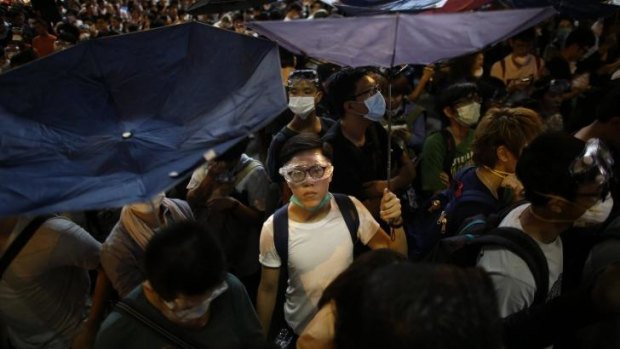 Defiant: A protester holds an umbrella during demonstrations.