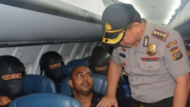 An Indonesian official poses for a photo with Bali Nine ringleader Myuran Sukumara on the flight from Bali to Cilacap.