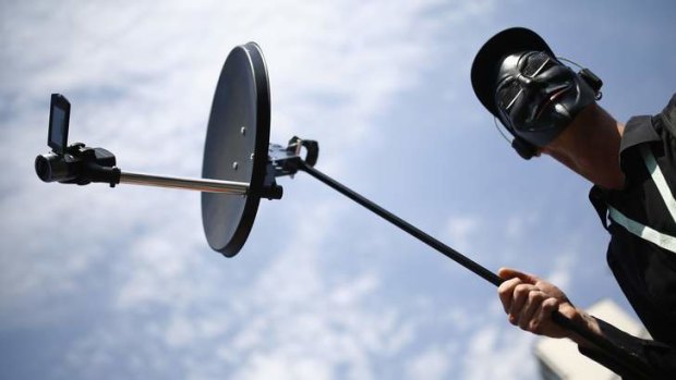 Listening in: A protester holds a mock bugging device at a rally in Frankfurt.