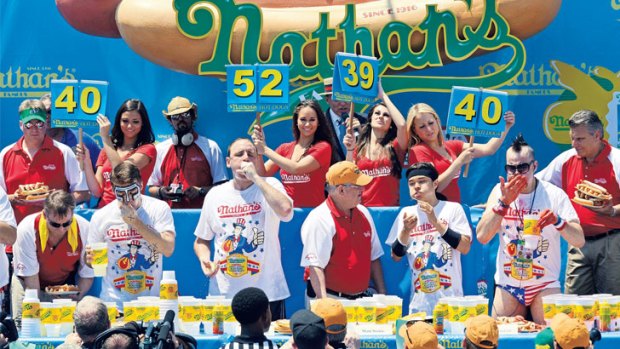 Conspicuous consumption: Joey Chestnut (second competitor from left) wins Nathan's Famous Fourth of July International Hot Dog Eating Contest in Coney Island in July.