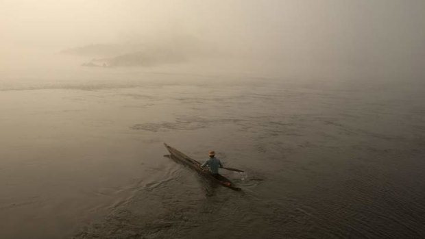 A country heads into unknown waters: A fisherman paddles his boat on the river Oubangui.