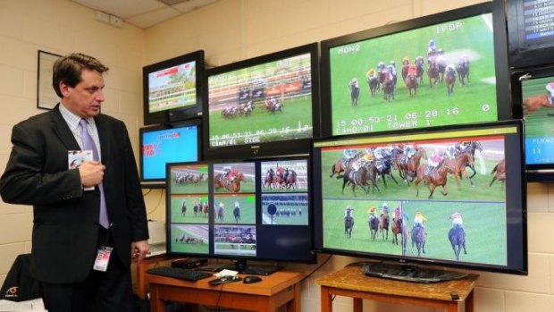 Chairman of stewards Terry Bailey has a look at the new Hawk-Eye video system at Flemington on Saturday.