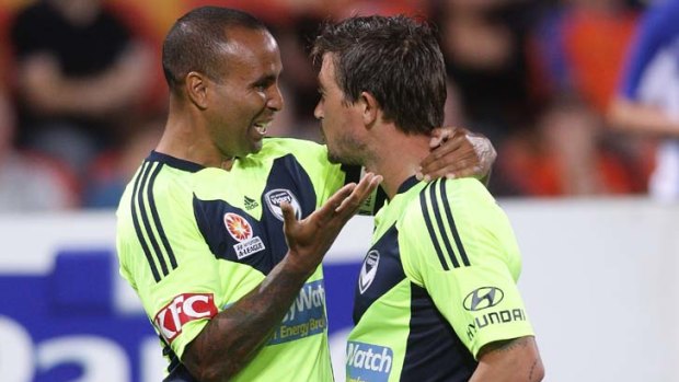Harry Kewell celebrates with Archie Thompson after scoring a goal during against the Roar.
