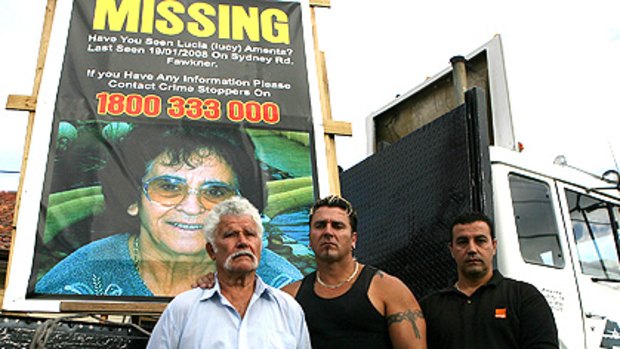 Paolo Amenta, left, with sons John and Paul in front of a poster of Lucia in February.
