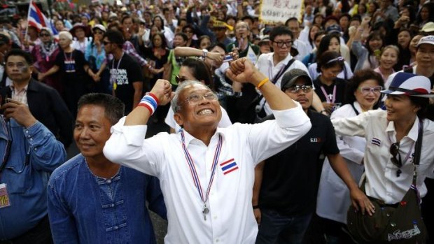 Protest leader Suthep Thaugsuban greets anti-government protesters as he marches through central Bangkok.