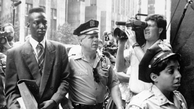 Arrested: Yusef Salaam being escorted by police in New York in 1990.