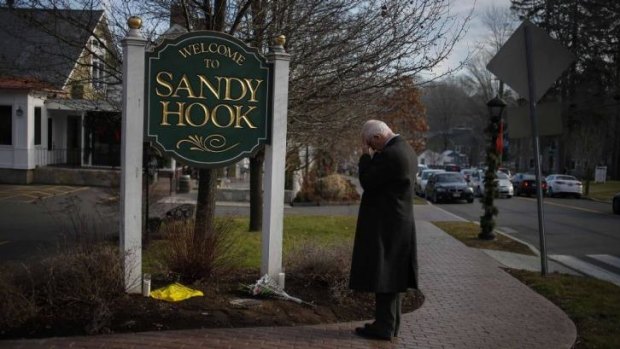 A man pauses to mourn at the entrance to the town of Sandy Hook on December 15, 2012, in the immediate aftermath of the tragedy.