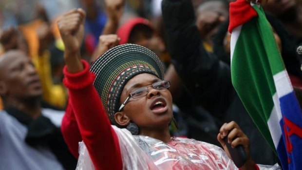 People start singing as they arrive for a mass memorial for the late South African president Nelson Mandela at FNB Stadium  in Johannesburg.