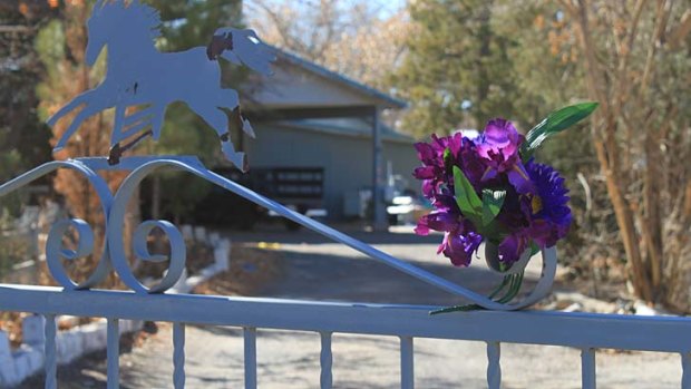 A family wiped out ...  a bouquet of flowers adorns the entrance to a home where Nehemiah Griego allegedly killed his parents and siblings.