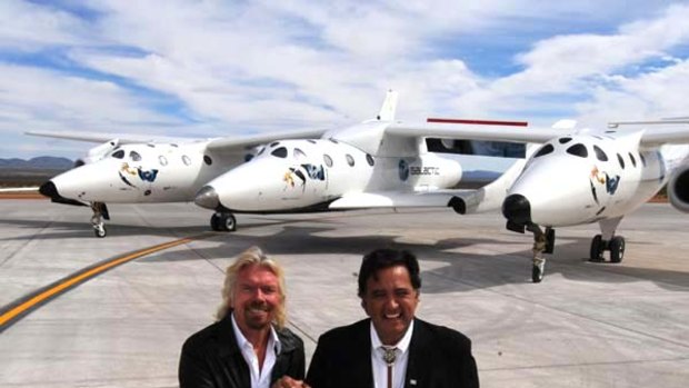 Virgin boss Richard Branson (L) and New Mexico Governor Bill Richardson (R) pose with the Virgin Galactic VSS Enterprise spacecraft after it's first public landing during the Spaceport America runway dedication ceremony.