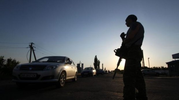 Tense: A pro-Russian militant stands guard at the Ukrainian-Russian border check-point near the city of Krasnopartizansk.