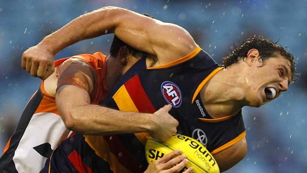 Giant hug: Kurt Tippett, Adelaide's four-goal hero, can't break Phil Davis' strong tackle.