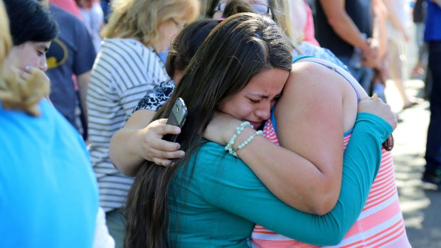 Grim toll: A woman is comforted after the shooting at Umpqua Community College.