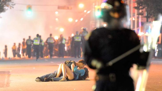 Stop for a kiss ...  this picture of a couple cosying up while a riot goes on around them in Vancouver has gone viral on the internet.