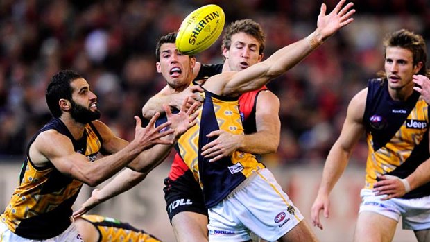 High five: Essendon's Cale Hooker lays a high tackle on Richmond's Alex Rance during their match at the MCG last night.