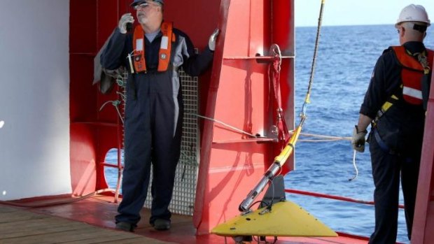 Specialists prepare to deploy the towed pinger locator on the Australian vessel Ocean Shield.