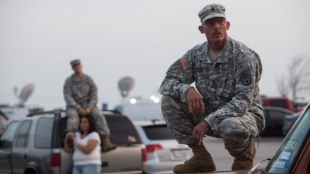 In shock ... Staff Sergeant John Robertson, right, waits in a parking lot outside of the Fort Hood military base for updates about the shooting that occurred inside on Wednesday.
