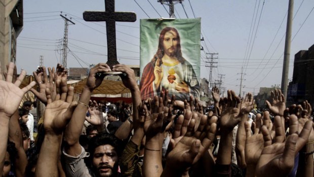Pakistani Christians raise their hands during a demonstration in Lahore, Pakistan, March, 2013.