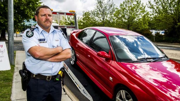 Sergeant Rod Anderson stands next to a tow truck as police warn that  they will seize vehicles from dangerous drivers at school formals.