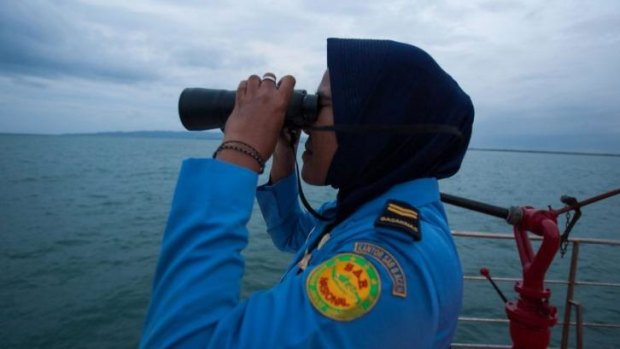 A member of Indonesia's National Search and Rescue looks for missing Malaysian Airlines flight MH370 in the Andaman Sea area around the northern tip of Indonesia's Sumatra island .