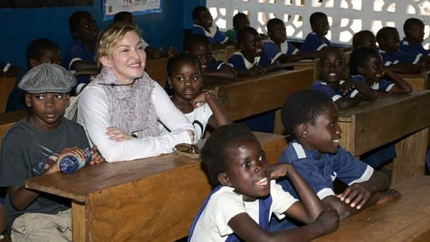 "Let's bring these people home!": Madonna seen here with the two children she adopted in Malawi, David Banda, left, and Mercy James, 3rd right, at the Mkoko Primary School.