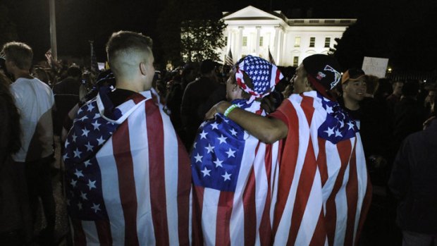 Announced ... revellers wrap themselves in US flags near the White House.