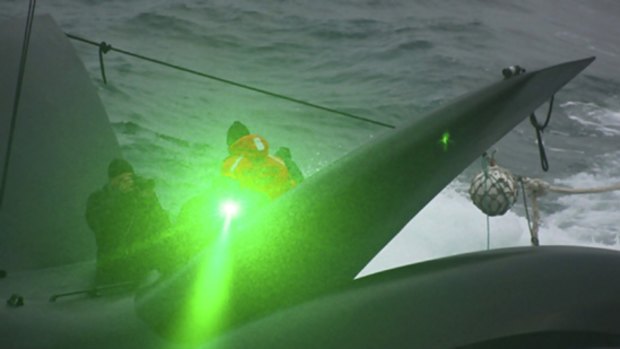 A Sea Shepherd activist sends what appears to be a green laser from the deck of the anti-whaling group's  vessel, the Ady Gil, towards the Japanese whaling ship Shonan Maru No. 2.