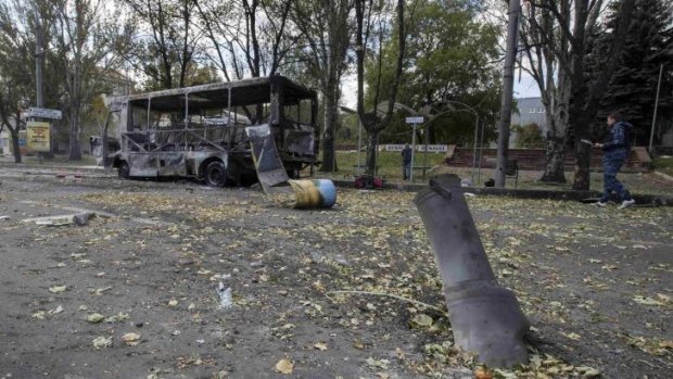 Carnage: The remains of a rocket shell is seen in front of a burnt-out bus on a street in Donetsk. At least 10 people were killed when shells hit a school playground.