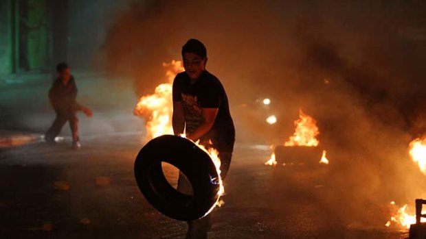 Burning issue ... a young demonstrator prepares to throw a tyre during a protest against the high cost of living near Ramallah.