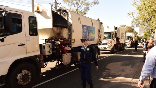 Police guide Blacktown garbage trucks during a protest over Struggle Street.