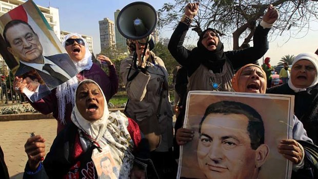 To be retried ... Egypt's deposed president Hosni Mubarak. Above, his supporters.