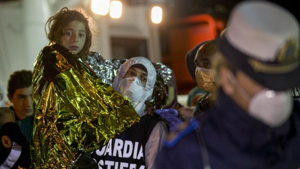 A migrant is helped disembark in Pozzallo after being rescued.