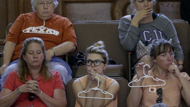 Opponents to an abortion bill sit in the senate chamber as Wendy Davis speaks.