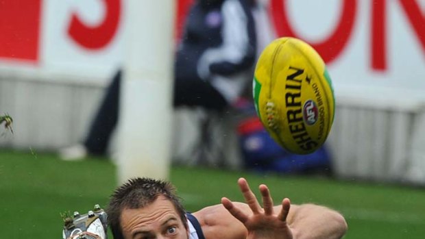 Slip up: Geelong's Joel Corey tries in vain to gather the wet ball.