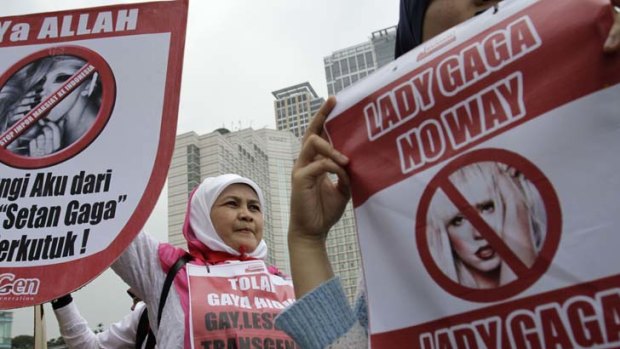 A woman holds up an anti-Lady Gaga poster in Jakarta.