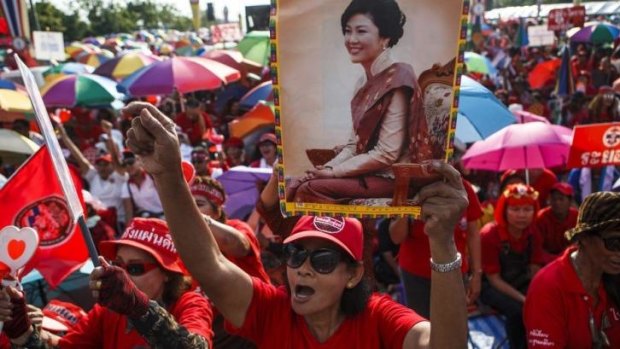 A member of the pro-government "red shirt" group holds a picture of ousted Thai prime minister Yingluck Shinawatra.