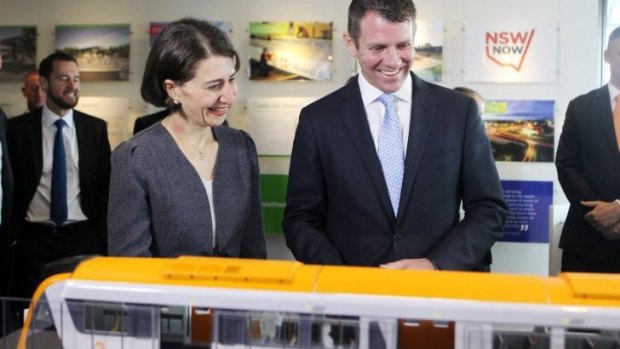 All aboard: Mr Baird and Ms Berejiklian study a model of the new trains.