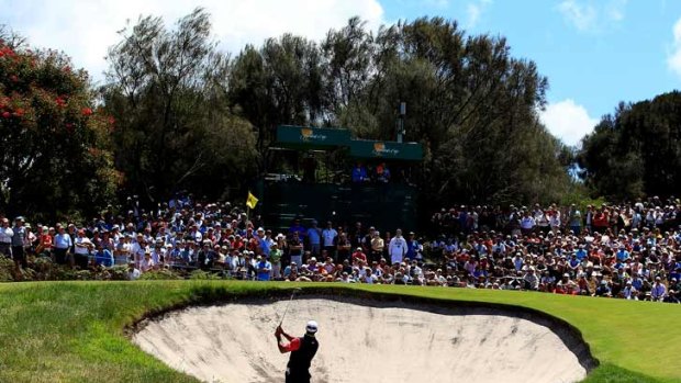 Tiger Woods hits out of a bunker on the 4th hole.