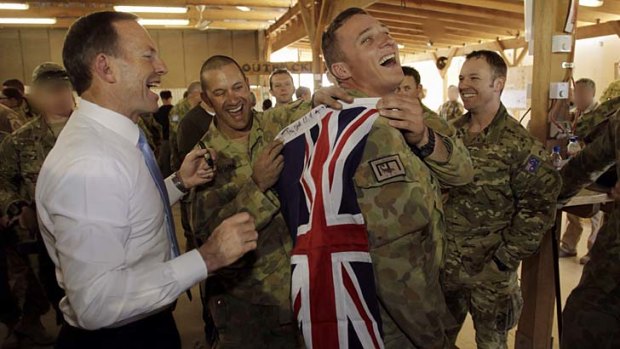 Prime Minister Tony Abbott, pictured with troops during a recent visit to Tarin Kowt, has announced the last Australian soldiers left Oruzgan on Sunday.