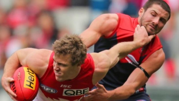 Plays in the Swans' physical style: Luke Parker fends off Melbourne's Colin Garland.