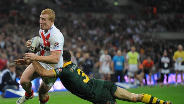 Jack Reed of England is tackled by Greg Inglis of Australia.