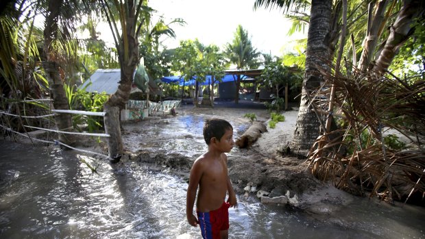 Kiribati / Climate Change : 291115: SMH News: 29th of November 2015: A child wades through sludge and water on the Island Republic of Kiribati in the Central Pacific Ocean. Kiribati often experiences inundation on high tides and is one of a number of low-lying nations exposed to the worst effects of rising waters due to climate change : Photo by James Alcock:

Kiribati photo James Alcock 6685.jpg