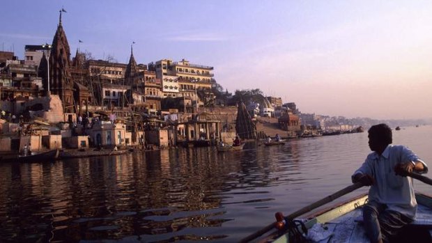 A boatman at dawn on the Ganges River beside the holy city of Varanasi in India.