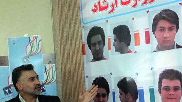 Acceptable ... an Iranian official shows pictures of authorised hairstyles.
