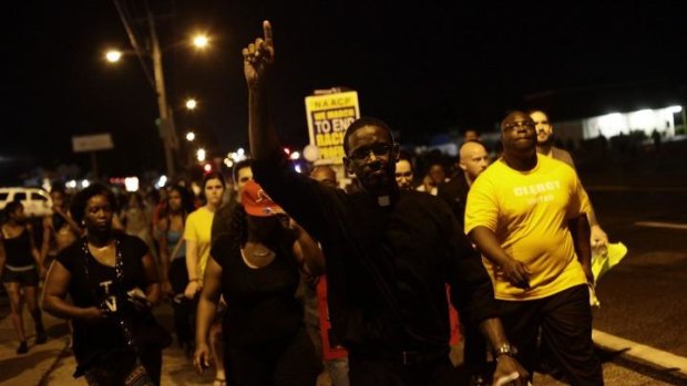 A clergyman leads demonstrators in a peaceful protest march over the shooting death of Michael Brown on Wednesday night in Ferguson.